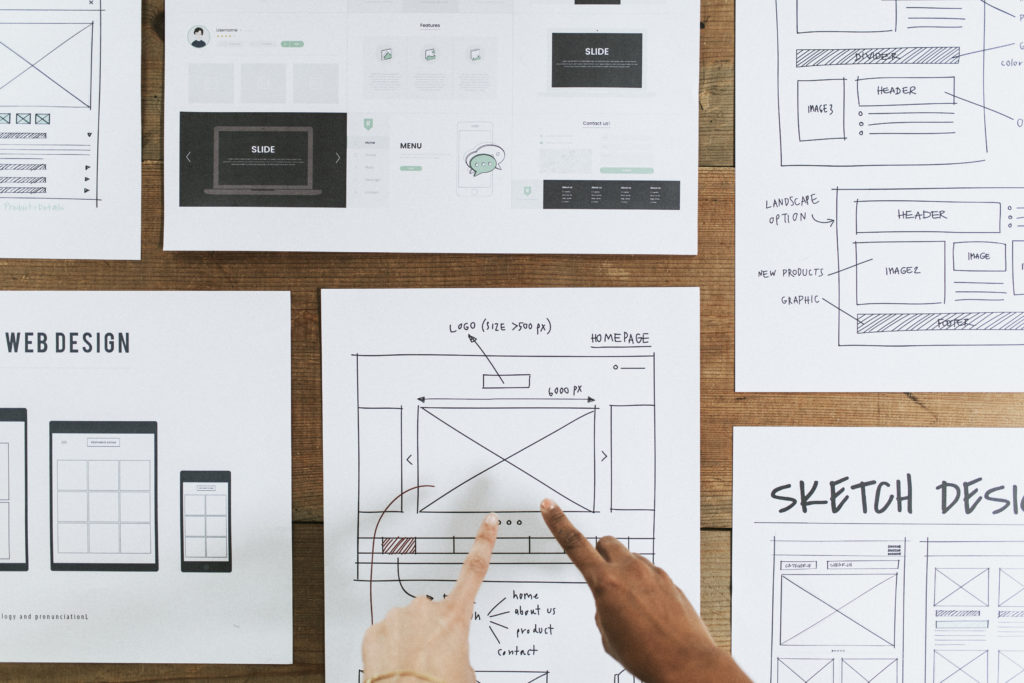 Hands pointing to a web design document